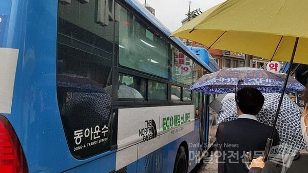 비가 내리는 19일 오전 서울시내에서 출근길 시민들이 우산을 받쳐들고 버스에 오르고 있다.(신윤희 기자)