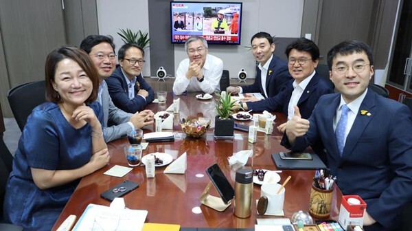 더불어민주당 소속의 박주민(왼쪽 세번째부터), 최강욱(네번째), 김남국(맨오른쪽)과 함께 황운하(여섯번째)이 환한 표정으로 기념사진을 찍고 있다. 최 의원 뒤편으로 대전의 물난리를 전하는 뉴스방송이 나오고 있다. /최강욱 의원 페이스북