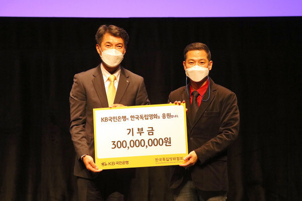 성채현 KB국민은행 개인고객그룹 부행장(왼쪽)과 고영재 한국독립영화협회 이사장이 기부금 협약식을 진행하고 기념촬영을 하고 있다. /KB국민은행 제공