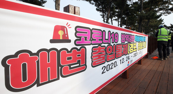 연말연시 해맞이 관광객에 의한 코로나19 대확산이 우려되자 23일 강원 강릉시가 경포 해변 주변에 출입을 차단한다는 현수막을 내걸었다. /연합뉴스