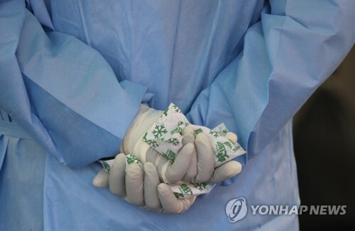 4일 오전 서울역 광장에 설치된 서울 중구 임시 선별검사소에서 관계자가 핫팩으로 손을 녹이고 있다. /연합뉴스