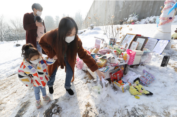 13일 오전 경기도 양평군 하이패밀리 안데르센 공원묘원에서 한 가족이 양부모의 학대로 생후 16개월 만에 숨진 정인 양을 추모하고 있다. /연합뉴스