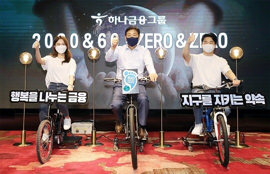 하나금융그룹은 51번째를 맞는 지구의 날인 22일 오전 서울 마포구 홍대 앞에 위치한 'H-PULSE'에서 그룹 「2030 & 60」·「ZERO & ZERO」 선언 행사를 가졌다. 김정태 하나금융그룹 회장(사진 가운데)과 하나 핫튜버들이 친환경 자가발전 자전거 세리머니를 하고 있다. (사진=하나금융그룹)