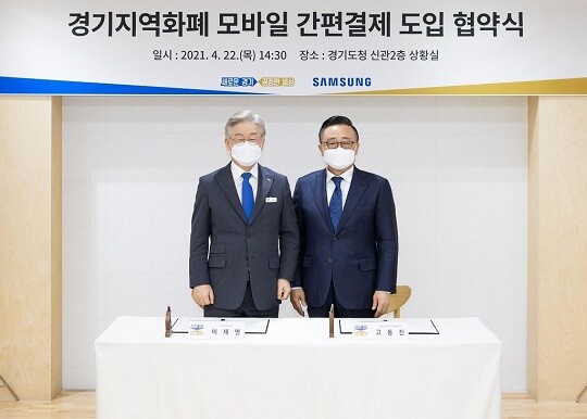 22일 경기도청 상황실에서 이재명 경기도지사 (왼쪽)과 고동진 삼성전자 대표이사 (오른쪽)이 '경기 지역화폐 간편결제 도입을 위한 업무협약'을 체결한 뒤 기념촬영을 하고 있다. (사진=연합)