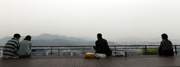 황사가 예보된 28일 서울 남산공원에서 시민들이 도심을 내려다보고 있다.  /연합뉴스
