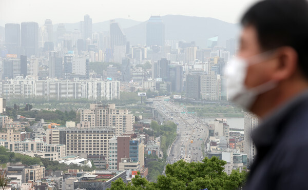 황사가 예보된 28일 서울 남산공원에서 한 시민이 도심을 내려다보고 있다. /연합뉴스
