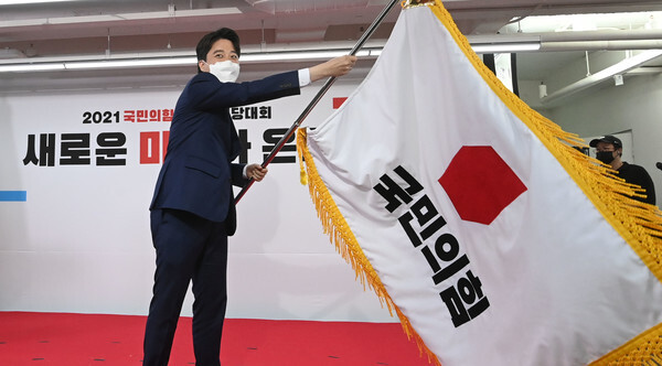 국민의힘 이준석 새 당 대표가 11일 서울 여의도 중앙당사에서 열린 전당대회에서 당기를 흔들고 있다.  /연합뉴스