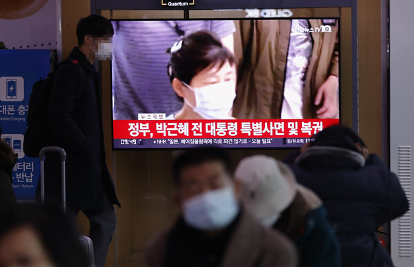 24일 오전 서울역에서 시민들이 박범계 법무부 장관의 사면 관련 발표 방송을 보고 있다.  /연합뉴스